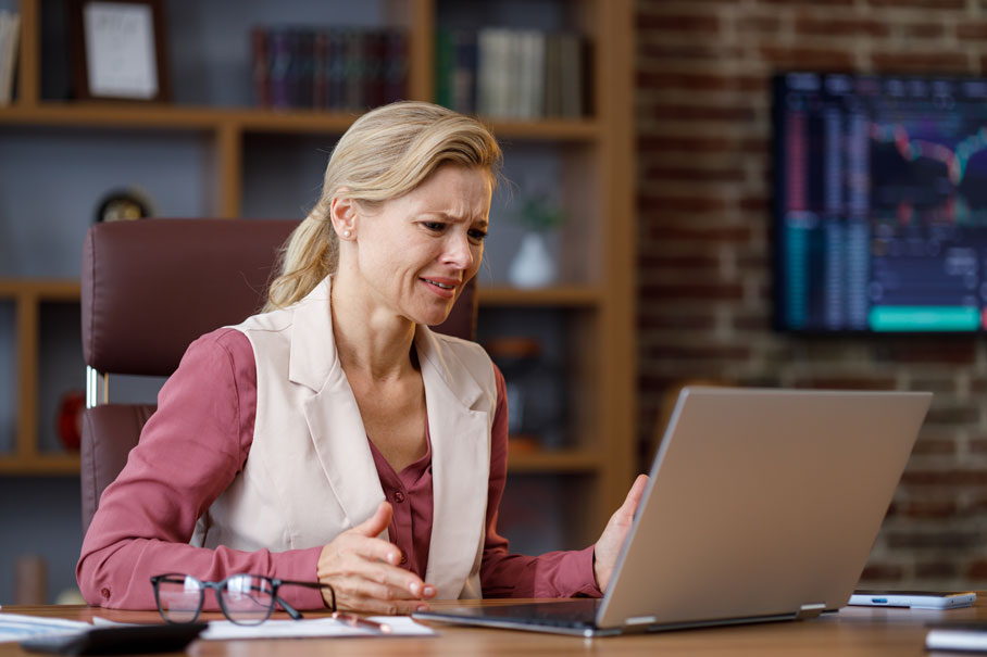 Lady stressed about paying care home fees at laptop