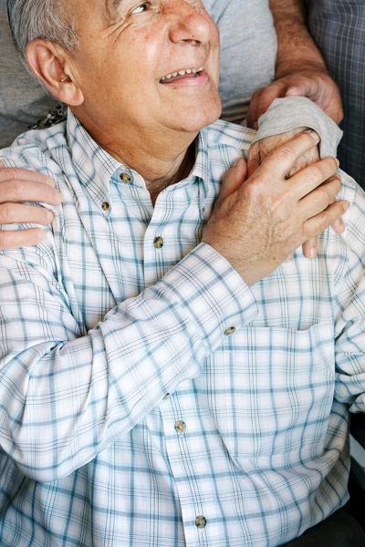 Caring for elderly clients - man in wheelchair with family around him